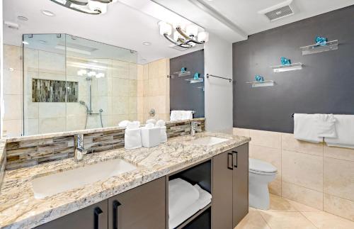 a bathroom with two sinks and a mirror at The Whaler By Maui Resort Rentals in Lahaina