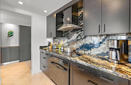 a kitchen with a marble counter top and stainless steel appliances at The Whaler By Maui Resort Rentals in Lahaina