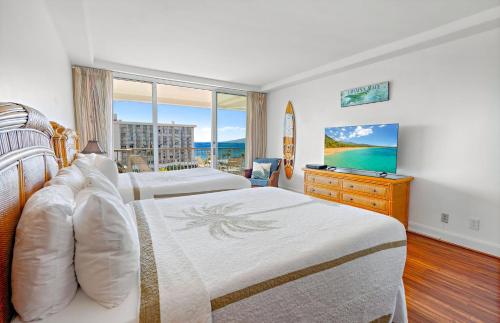 a hotel room with two beds and a television at The Whaler By Maui Resort Rentals in Lahaina