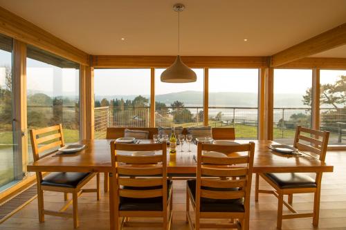 a dining room with a large wooden table and chairs at Nantsaeson in Cardigan