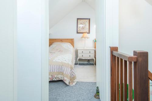 a bedroom with a bed and a table with a lamp at Rose Cottage in Solva