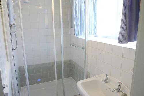 a bathroom with a shower and a sink at Rose Cottage in Solva