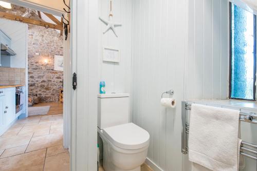 ein weißes Badezimmer mit Toilette und Waschbecken in der Unterkunft Little Rogeston Cottage in Haverfordwest