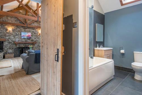 baño con bañera, aseo y chimenea en Little Folly, en Haverfordwest