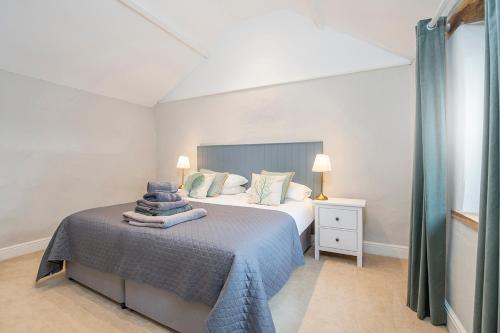 1 dormitorio blanco con 1 cama con manta azul en Little Folly, en Haverfordwest
