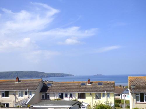 a row of houses with the ocean in the background at Cariad Y Mor in Broad Haven