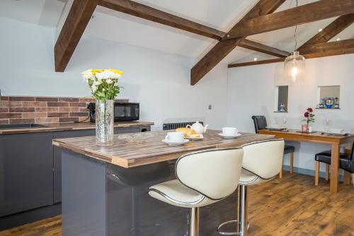 a kitchen with a island with a vase of flowers at Sovereign Suite in Saundersfoot