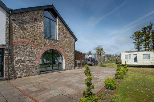 a brick house with a patio in the yard at Sovereign Suite in Saundersfoot