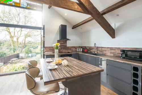 a kitchen with a wooden table and chairs in it at Sovereign Suite in Saundersfoot