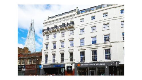 a large white building with the shard in the background at St Christopher's Inn London Bridge - Oasis Female Only in London
