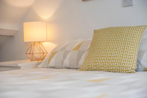a bed with a yellow pillow and a lamp at Ty Cranc Mawr in Haverfordwest