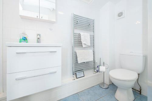 a white bathroom with a toilet and towels at Willowcot Cottage in Haverfordwest