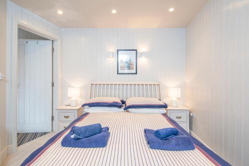 a bedroom with a large bed with two blue pillows at Lower Deck in Tenby