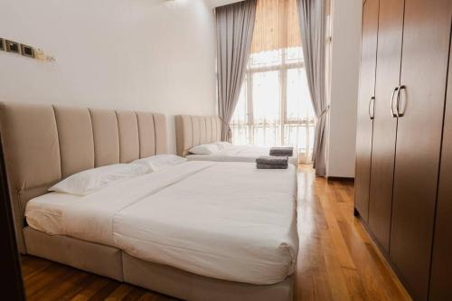 a large white bed in a room with a window at Gelugor 2Storey Big Bungalow 23pax with BBQ Snooker in Gelugor