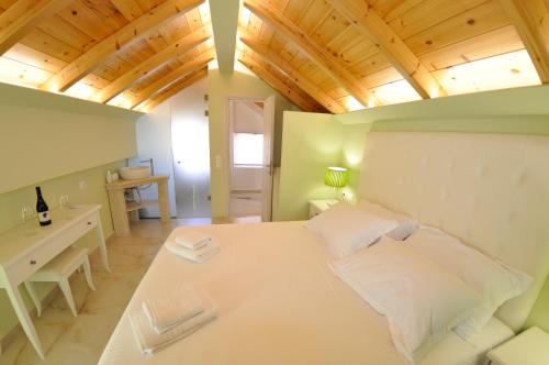 a bedroom with a large white bed and a desk at Agios Gordios Beach Resort in Agios Gordios