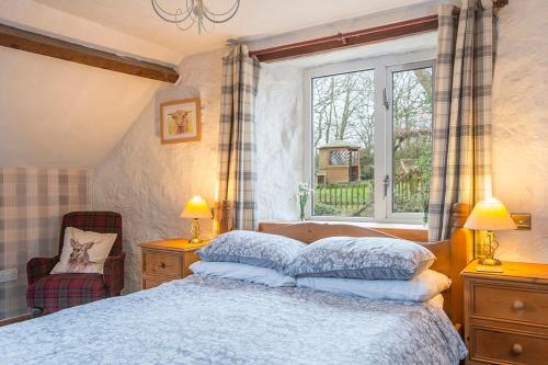 ein Schlafzimmer mit einem Bett und einem Fenster in der Unterkunft Honey Hook Cottage in Haverfordwest