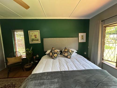 a bedroom with a bed with a green wall at Cedara Way Hilton in Hilton