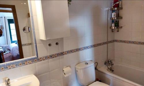 a bathroom with a toilet and a sink and a mirror at La vista encantada in Frigiliana