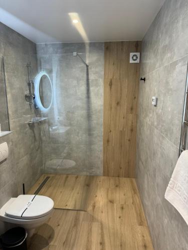 a bathroom with a white toilet and a shower at Guest House Zatyshnyi Dvir in Bukovel