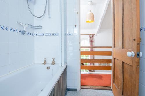 een badkamer met een douche en een trap met een deur bij Ty Canol in Goodwick