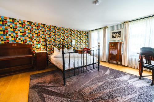 a bedroom with a bed and a colorful wall at Gasthaus Fiester Hannes in Burbach