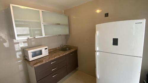 a kitchen with a white refrigerator and a sink at Estancia Iturriaga Suite 2 in Mexico City