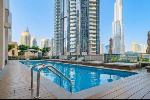 a swimming pool in a city with tall buildings at Chic 1BR Retreat , Blvd Views, Walk to Dubai Mall in Dubai