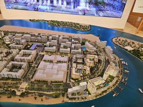 a model of a city with buildings and water at Apartments 100 m2 in Sharjah