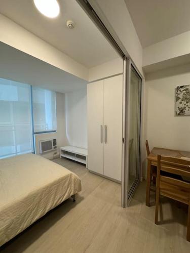 una camera da letto con un letto, un tavolo e una scrivania di Dwell a Manila