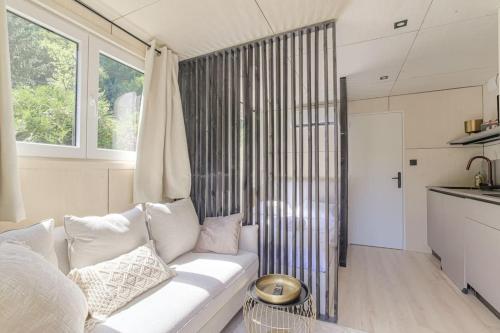 - un salon avec un canapé blanc et une fenêtre dans l'établissement Tiny-house atypique, 4 personnes, Saint-Didier, à Saint-Didier-au-Mont-dʼOr
