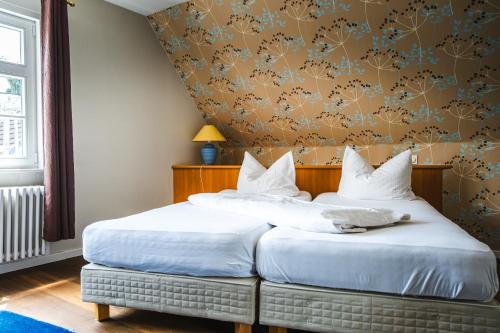 two beds sitting next to each other in a bedroom at Gasthaus Fiester Hannes in Burbach