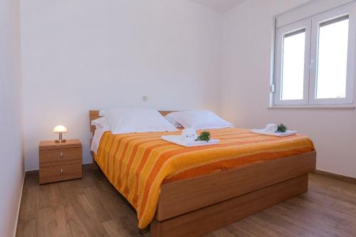 a bedroom with a bed with two towels on it at Apartments Zvone1 in Veli Rat