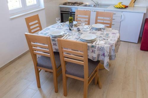 a dining room table with plates and glasses on it at Apartments Zvone1 in Veli Rat