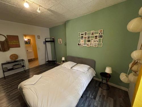 - une chambre avec un lit blanc dans un mur vert dans l'établissement T2 ancien hyper centre ville Orléans, à Orléans