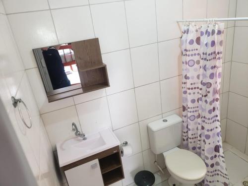 a small bathroom with a toilet and a sink at Pousada Aconchego in Peruíbe