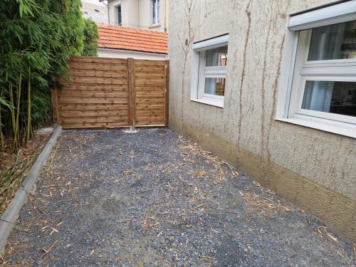 une arrière-cour avec une clôture en bois à côté d'un bâtiment dans l'établissement Maison au cœur de Tarbes, à Tarbes