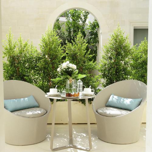 two chairs and a table in front of a window at La Fiermontina Luxury Home Hotel in Lecce