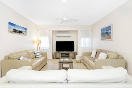 a living room with white furniture and a flat screen tv at 2 Story luxury beach house in Geographe