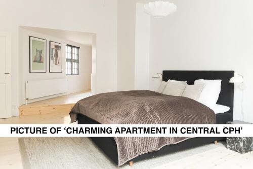 a bedroom with a bed with a picture of channelant apartment in central chi at Central City Apartment on Best Location by Round Tower in Copenhagen