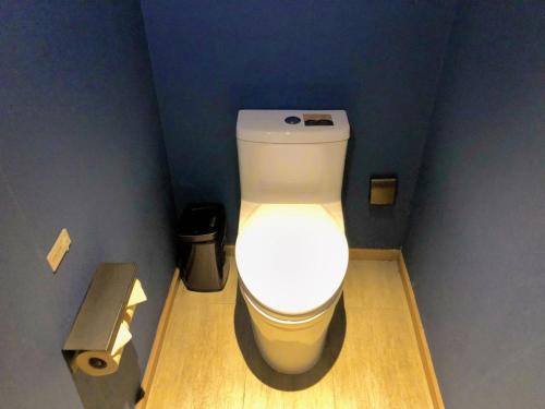 a bathroom with a white toilet in a blue wall at Atour Hotel (Xi'an Xiaozhainan, Qujiang Convention and Exhibition Center) in Xi'an