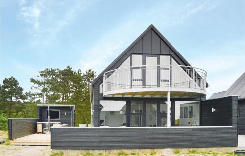 a black house with a balcony on top of it at Three-Bedroom Holiday Home In Romo in Sønderby