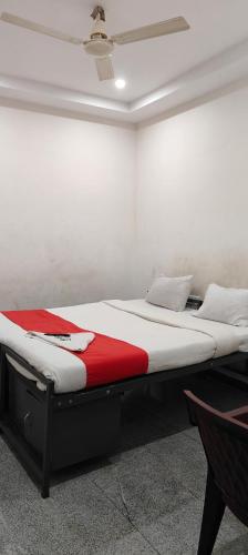 two beds in a room with a red and white mattress at Manjushree Lodging in Bengaluru
