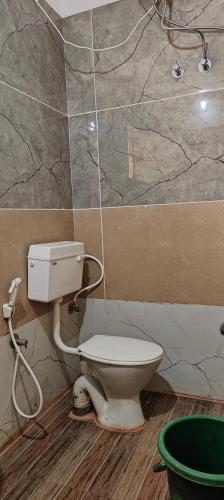 a bathroom with a toilet and a shower at Manjushree Lodging in Bengaluru