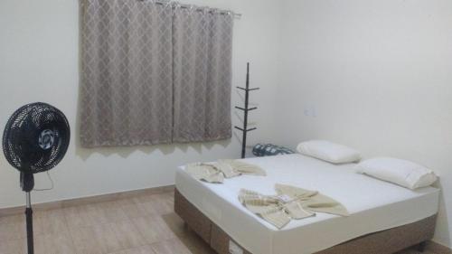 a bedroom with a bed with a fan and a window at Casa Boa Vista Serra Canastra in São Roque de Minas