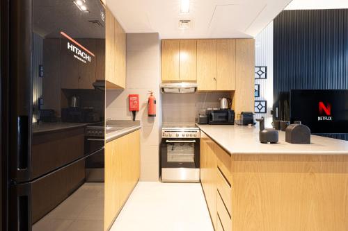 a kitchen with wooden cabinets and stainless steel appliances at 1BR Private Apartment in Center of Sharjah- Black Knight in Sharjah