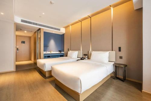 a hotel room with two beds and a bathroom at Atour Hotel (Xi'an Xiaozhainan, Qujiang Convention and Exhibition Center) in Xi'an