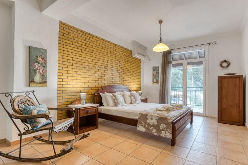 a bedroom with a bed and a chair at Kaminaki Villas by Tsiolis Family in Katávolos