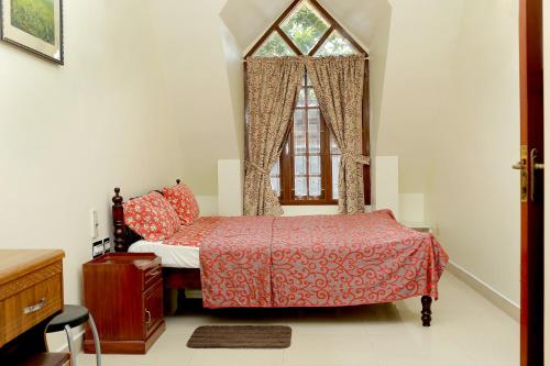 ein Schlafzimmer mit einem Bett und einem Fenster in der Unterkunft Leelu Homestay in Kochi