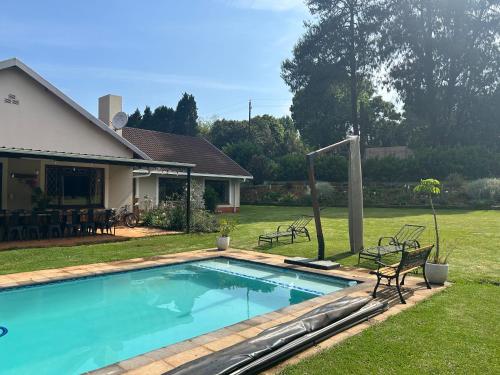 a swimming pool in a yard next to a house at Cedara Way Hilton in Hilton