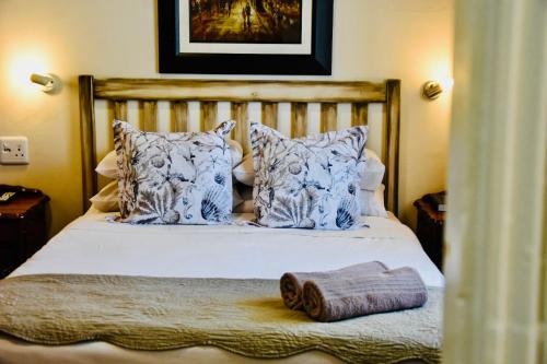 a bedroom with a bed with blue and white pillows at Donkin Country House in Beaufort West